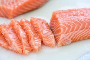slicing salmon fillets on a cutting board