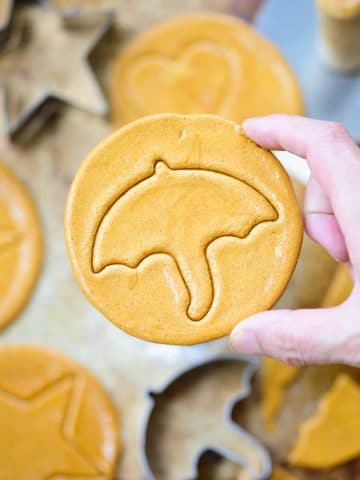 Holding up a round Korean honeycomb sugar candy with an umbrella imprint