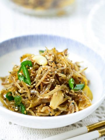 Stir-fried tiny dry anchovies in a small bowl with a blue trim