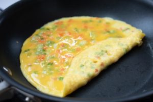 Rolling the thin sheet of the egg mixture