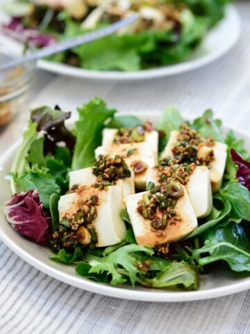 Boiled tofu on a bed of spring salad mix drizzled with a soy based sauce