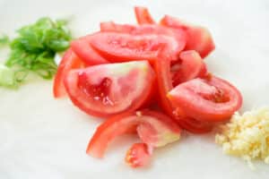 cutting tomato on a cutting board