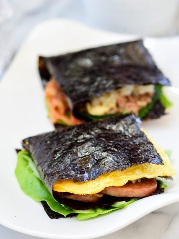 Two folded kimbap on a white plate