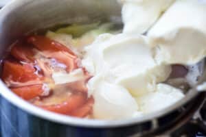 adding soft tofu to the soup in a pot