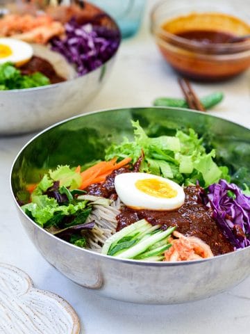 Cold noodles with colorful vegetables and a spicy gochujang sauce with a half boiled egg on top