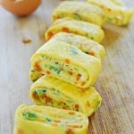 Korean rolled omelette with chopped carrot and scallion on a cutting board